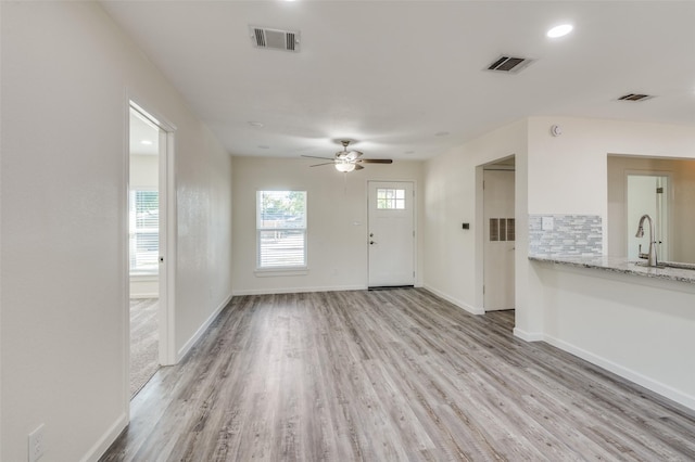 interior space featuring sink, ceiling fan, and light hardwood / wood-style flooring