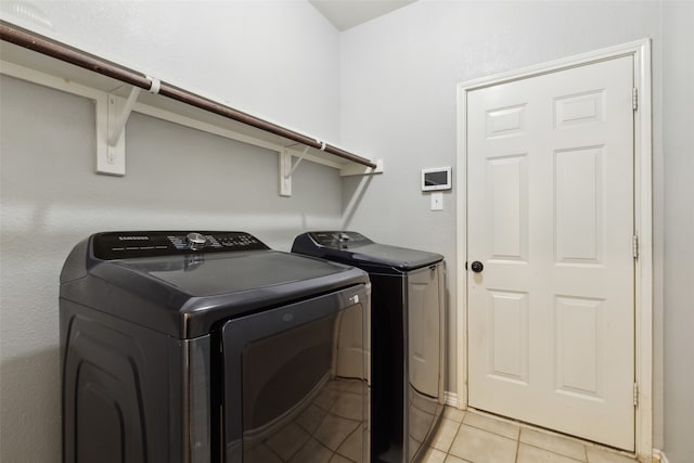 washroom featuring washer and clothes dryer and light tile patterned floors