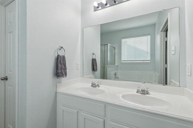 bathroom with vanity and shower with separate bathtub