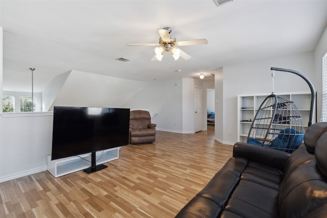 living room featuring ceiling fan, light wood-type flooring, and vaulted ceiling