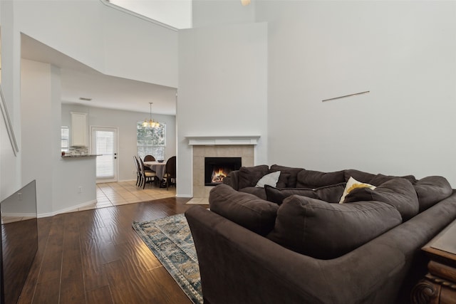 living room with a towering ceiling, a fireplace, and light hardwood / wood-style floors