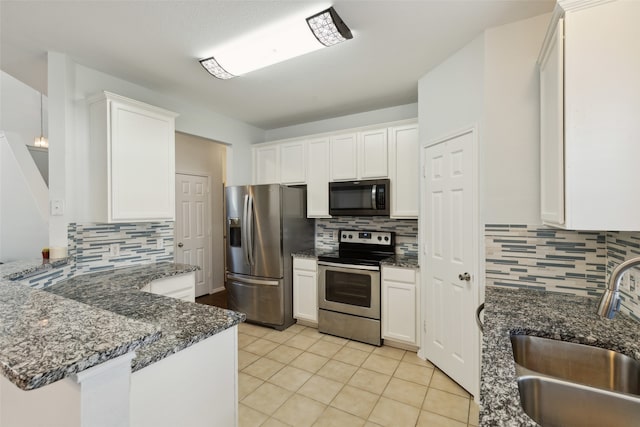 kitchen featuring white cabinetry, sink, appliances with stainless steel finishes, dark stone countertops, and backsplash