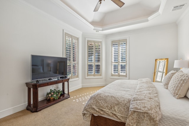 carpeted bedroom with a raised ceiling, ceiling fan, and crown molding