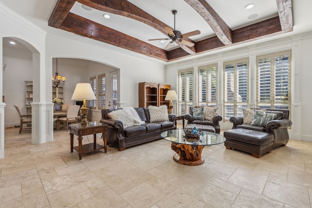 living room with beamed ceiling, ceiling fan with notable chandelier, ornate columns, and crown molding