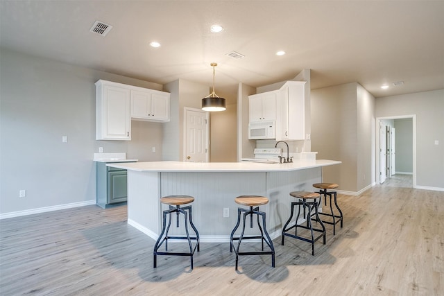 kitchen with white cabinets, white appliances, a breakfast bar area, and blue cabinets