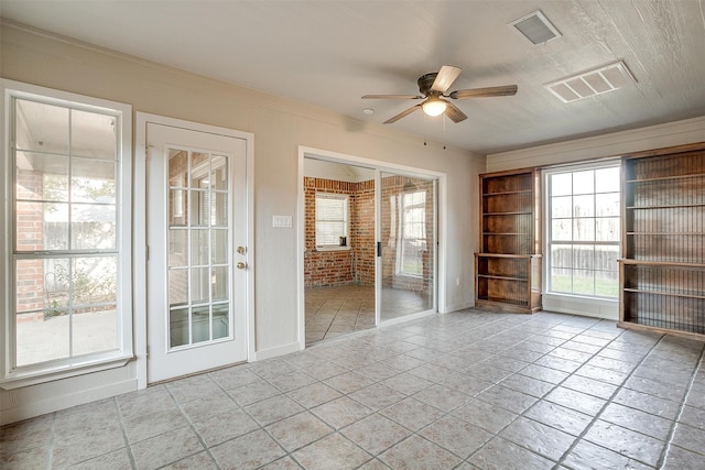 unfurnished room with ceiling fan and crown molding