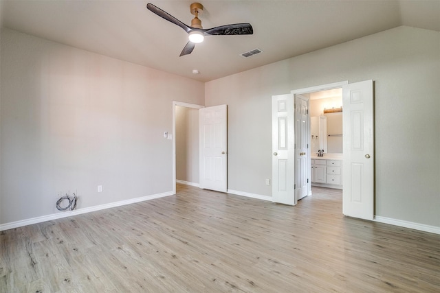 unfurnished bedroom with light hardwood / wood-style flooring, lofted ceiling, ceiling fan, and connected bathroom