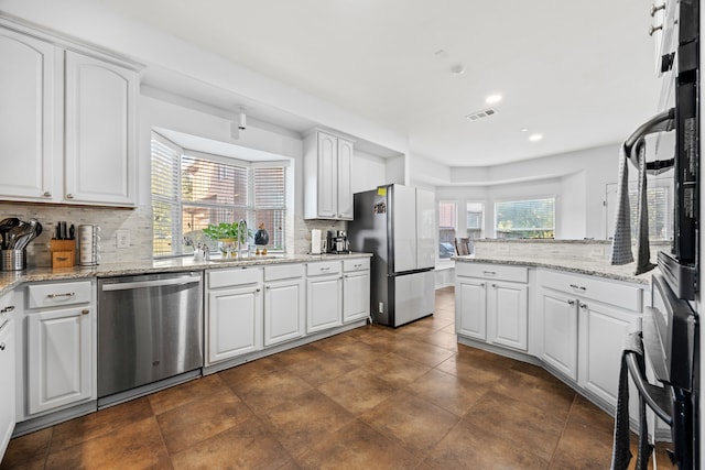 kitchen with decorative backsplash, appliances with stainless steel finishes, sink, and white cabinets