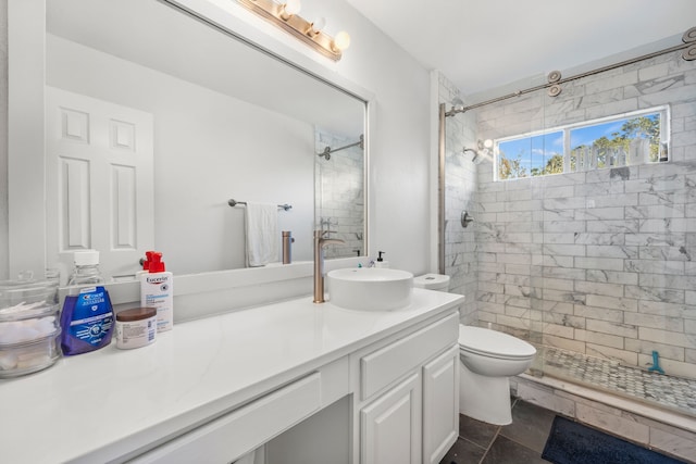 bathroom featuring vanity, tile patterned floors, toilet, and a tile shower