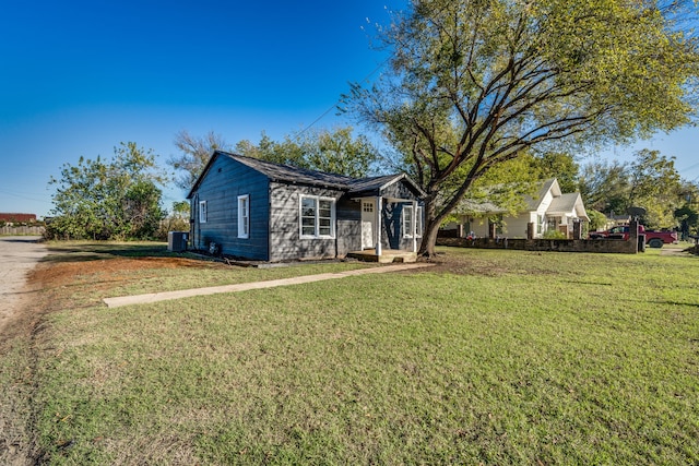 ranch-style home featuring a front lawn and central AC