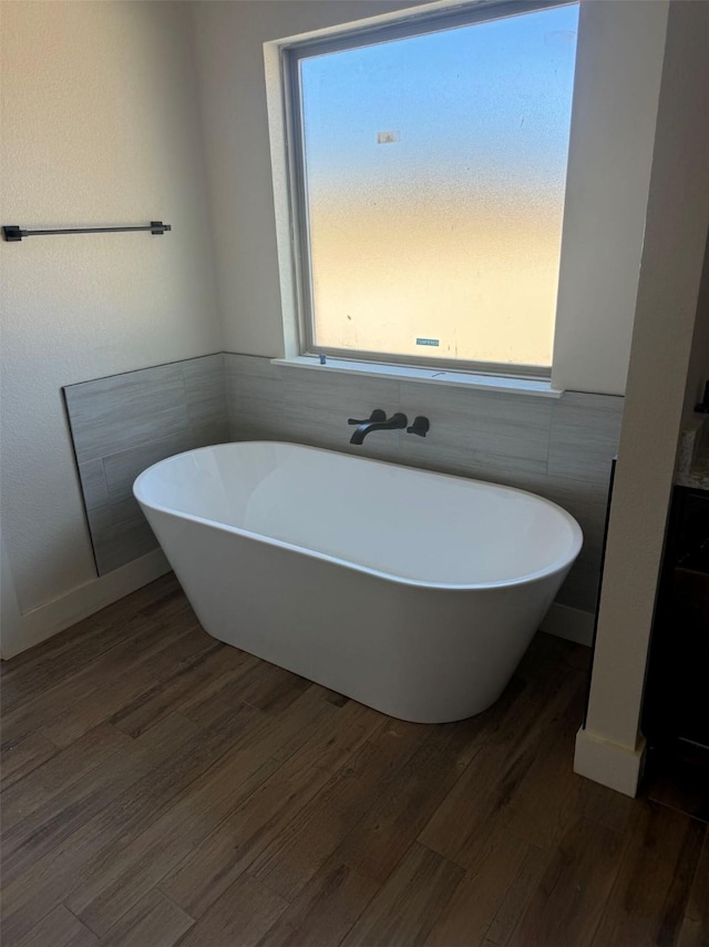 bathroom featuring a washtub and hardwood / wood-style flooring