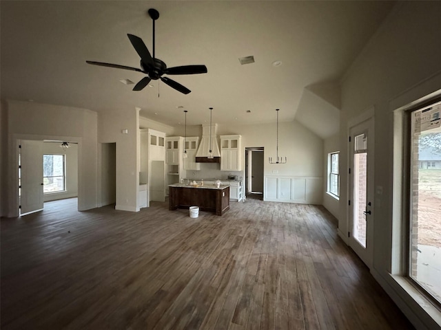 unfurnished living room with ceiling fan, dark wood-type flooring, and vaulted ceiling