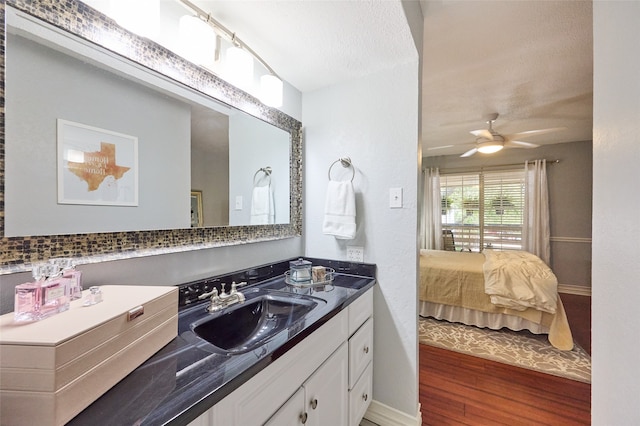 bathroom featuring vanity, hardwood / wood-style floors, ceiling fan, and a textured ceiling