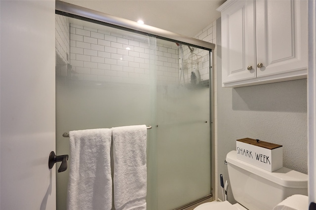 bathroom with toilet and an enclosed shower