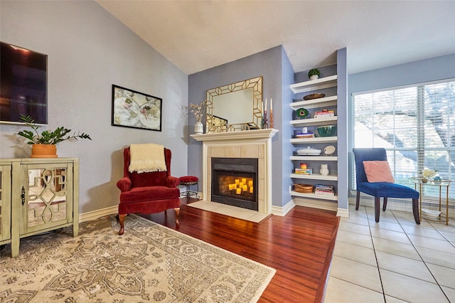 living area featuring hardwood / wood-style floors, a fireplace, and lofted ceiling