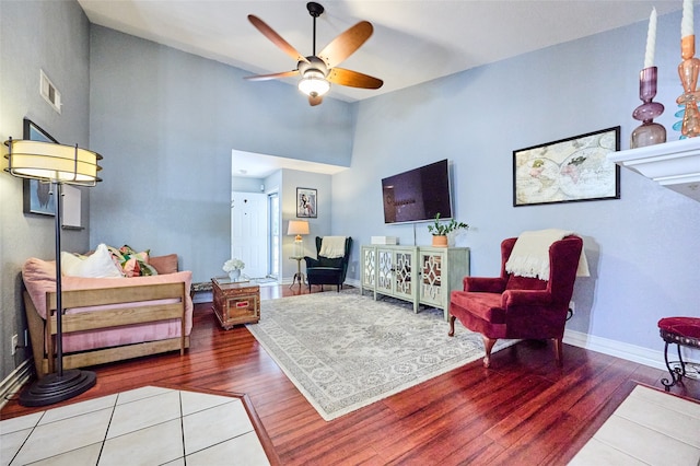 living room featuring hardwood / wood-style floors, a high ceiling, and ceiling fan