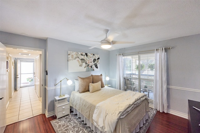 bedroom featuring a textured ceiling, dark wood-type flooring, and ceiling fan