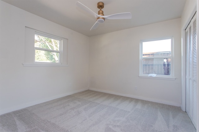 spare room featuring light carpet and ceiling fan