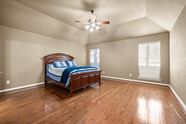 bedroom with wood-type flooring, multiple windows, ceiling fan, and vaulted ceiling