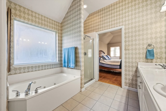 bathroom featuring plus walk in shower, vanity, vaulted ceiling, and tile patterned floors