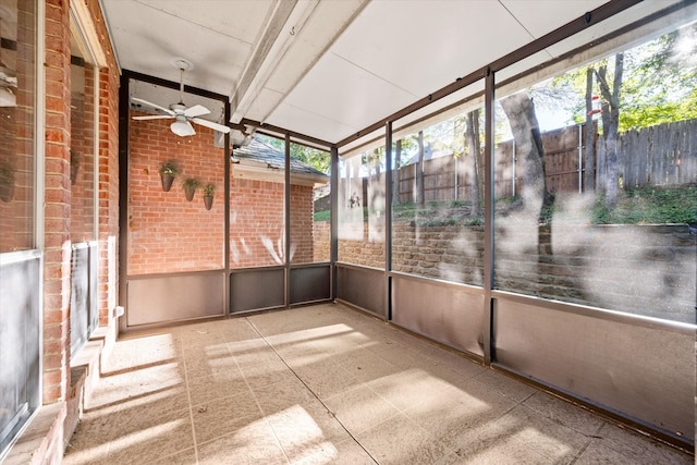 unfurnished sunroom featuring a wealth of natural light and ceiling fan