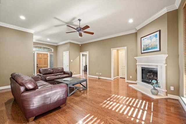 living room with ornamental molding, ceiling fan, and light hardwood / wood-style floors