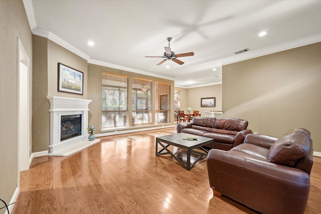 living room featuring light wood-type flooring, ceiling fan, and crown molding