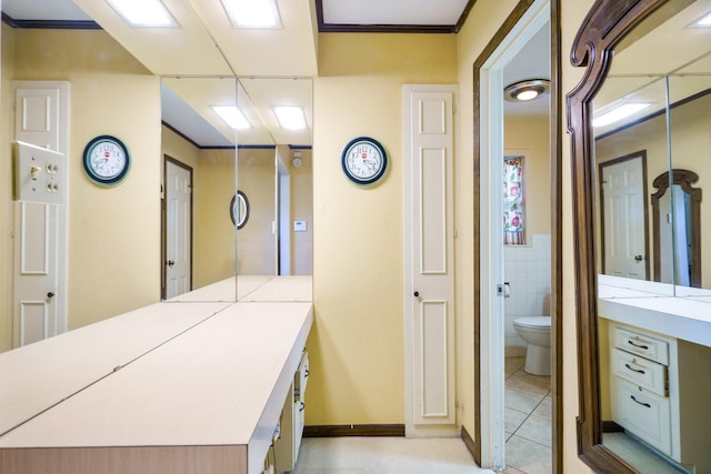 corridor featuring ornamental molding and light tile patterned flooring