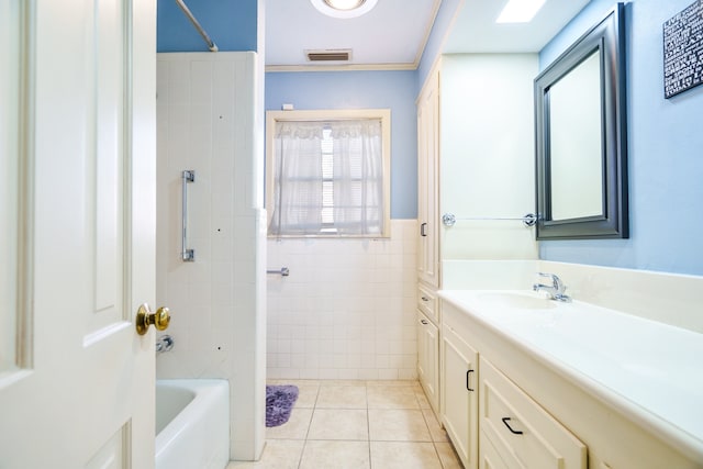 bathroom with vanity, tile patterned floors, tiled shower / bath, and tile walls