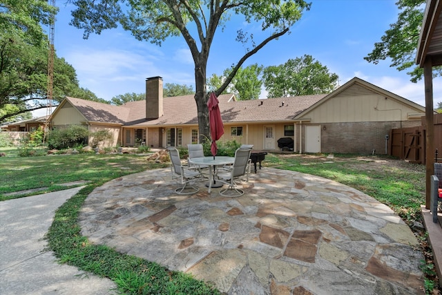 back of house featuring a patio area and a lawn