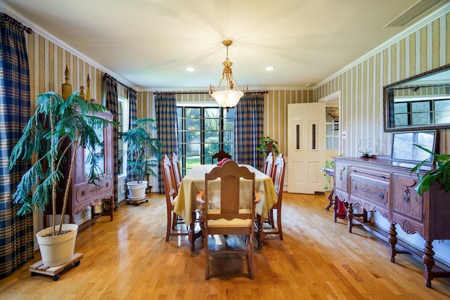 dining room featuring light wood-type flooring and crown molding