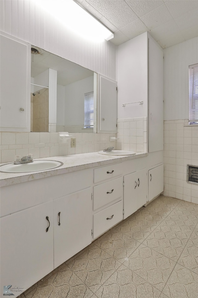 bathroom with tile patterned flooring, vanity, and tile walls