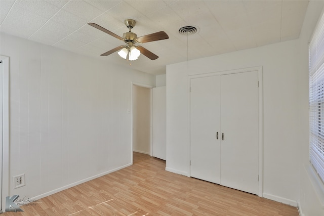 unfurnished bedroom featuring a closet, ceiling fan, and light hardwood / wood-style flooring