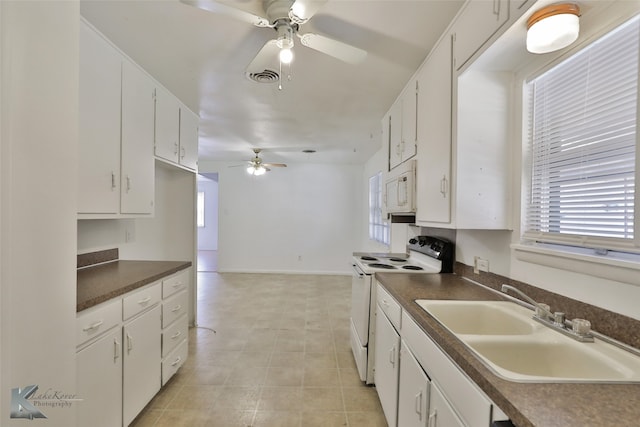 kitchen with white cabinets, a wealth of natural light, sink, and white appliances