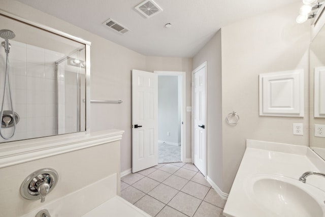 bathroom featuring tile patterned flooring, vanity, and a shower