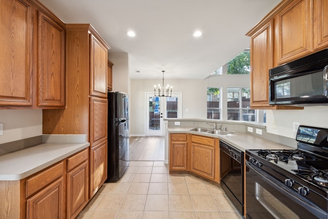 kitchen with sink, black appliances, light tile patterned floors, a notable chandelier, and pendant lighting