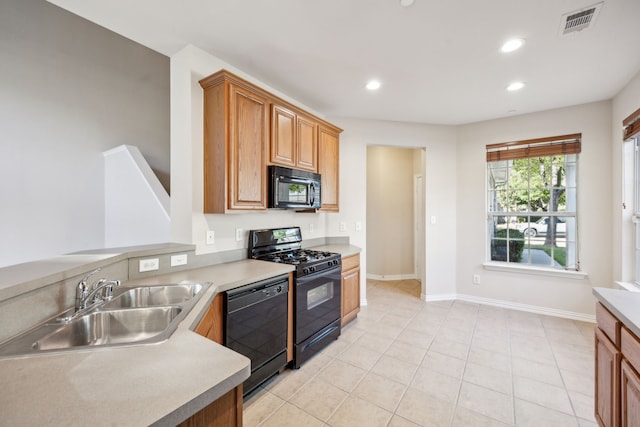 kitchen with black appliances, sink, and light tile patterned floors