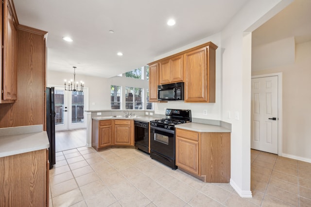 kitchen featuring sink, black appliances, kitchen peninsula, an inviting chandelier, and hanging light fixtures