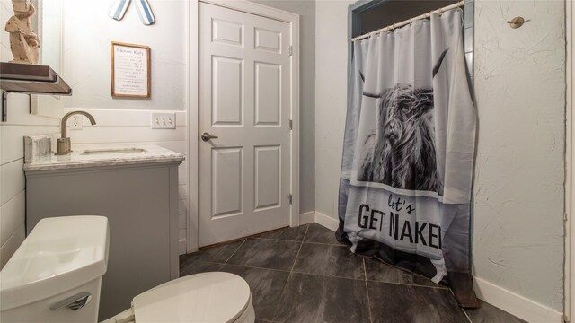 bathroom featuring curtained shower, vanity, and toilet