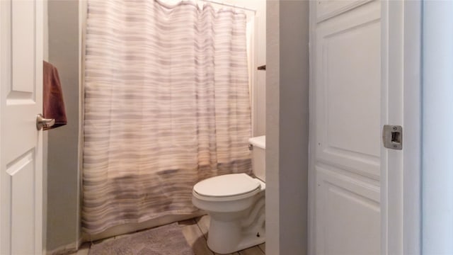 bathroom with a shower with curtain and toilet