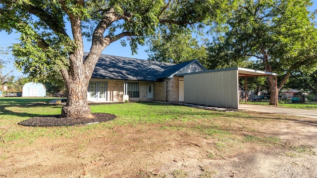 view of front of home with a shed, a front yard, and a carport