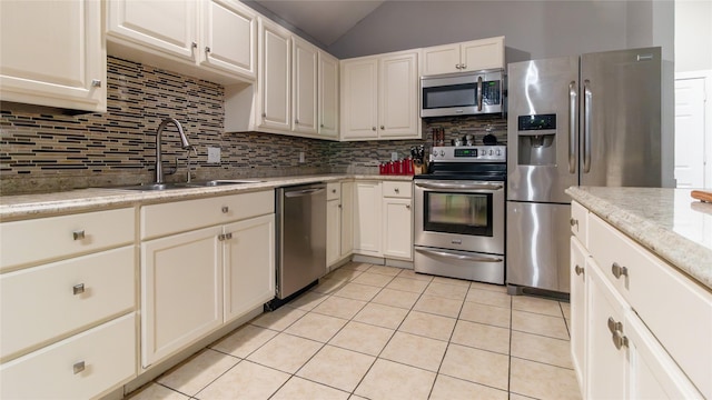 kitchen featuring backsplash, light tile patterned floors, sink, and appliances with stainless steel finishes