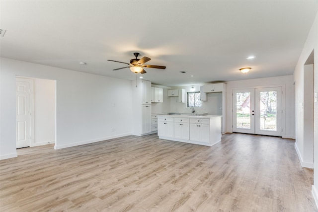 unfurnished living room featuring ceiling fan, french doors, light hardwood / wood-style floors, and sink