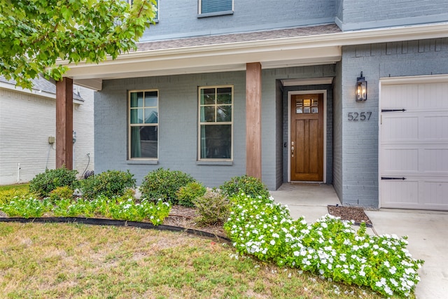 entrance to property with a garage and covered porch