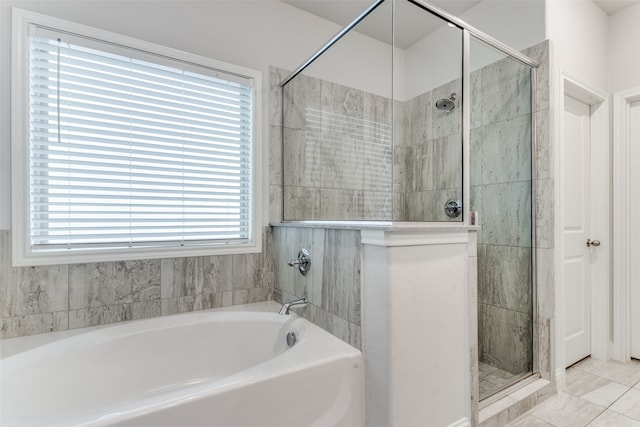 bathroom featuring independent shower and bath, a healthy amount of sunlight, and tile patterned floors