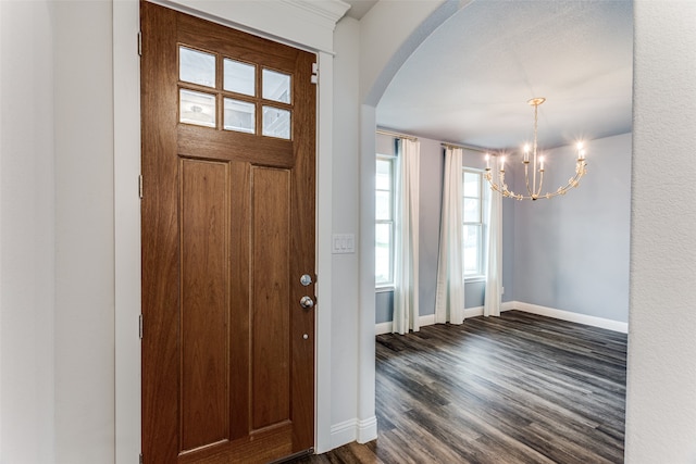 foyer entrance featuring dark hardwood / wood-style floors and a chandelier