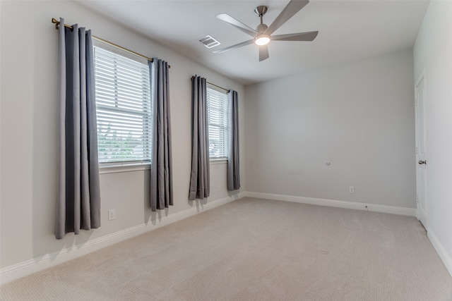 carpeted spare room featuring ceiling fan