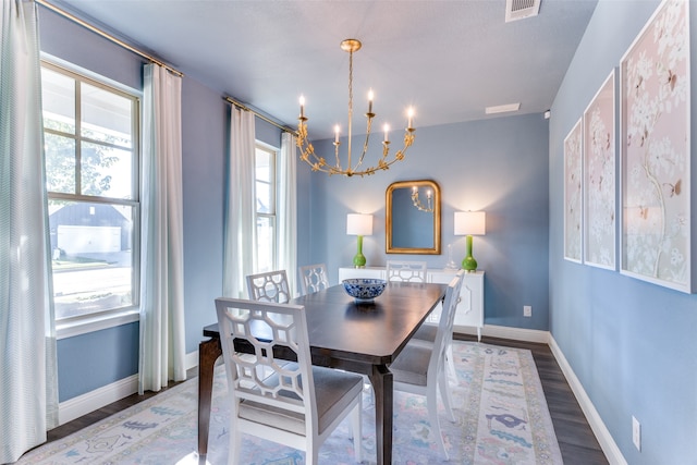 dining space featuring hardwood / wood-style floors and a chandelier