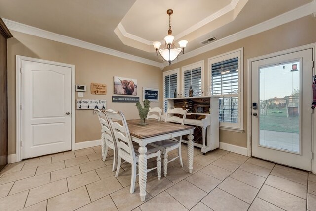 tiled dining room featuring a tray ceiling, crown molding, and a notable chandelier