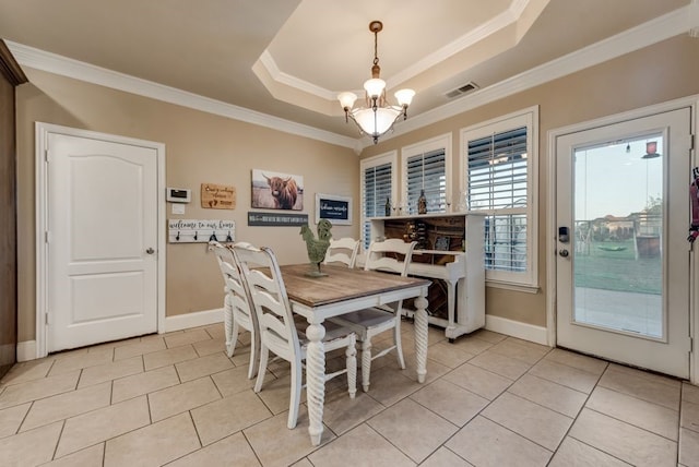 dining area featuring crown molding, light tile patterned flooring, a notable chandelier, and a tray ceiling